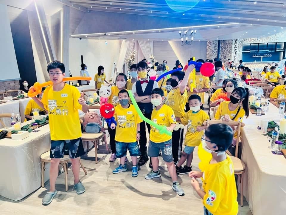 演出後穿黃色上衣的孩子們拿著氣球劍與蜘蛛人氣球圍在柯男身邊