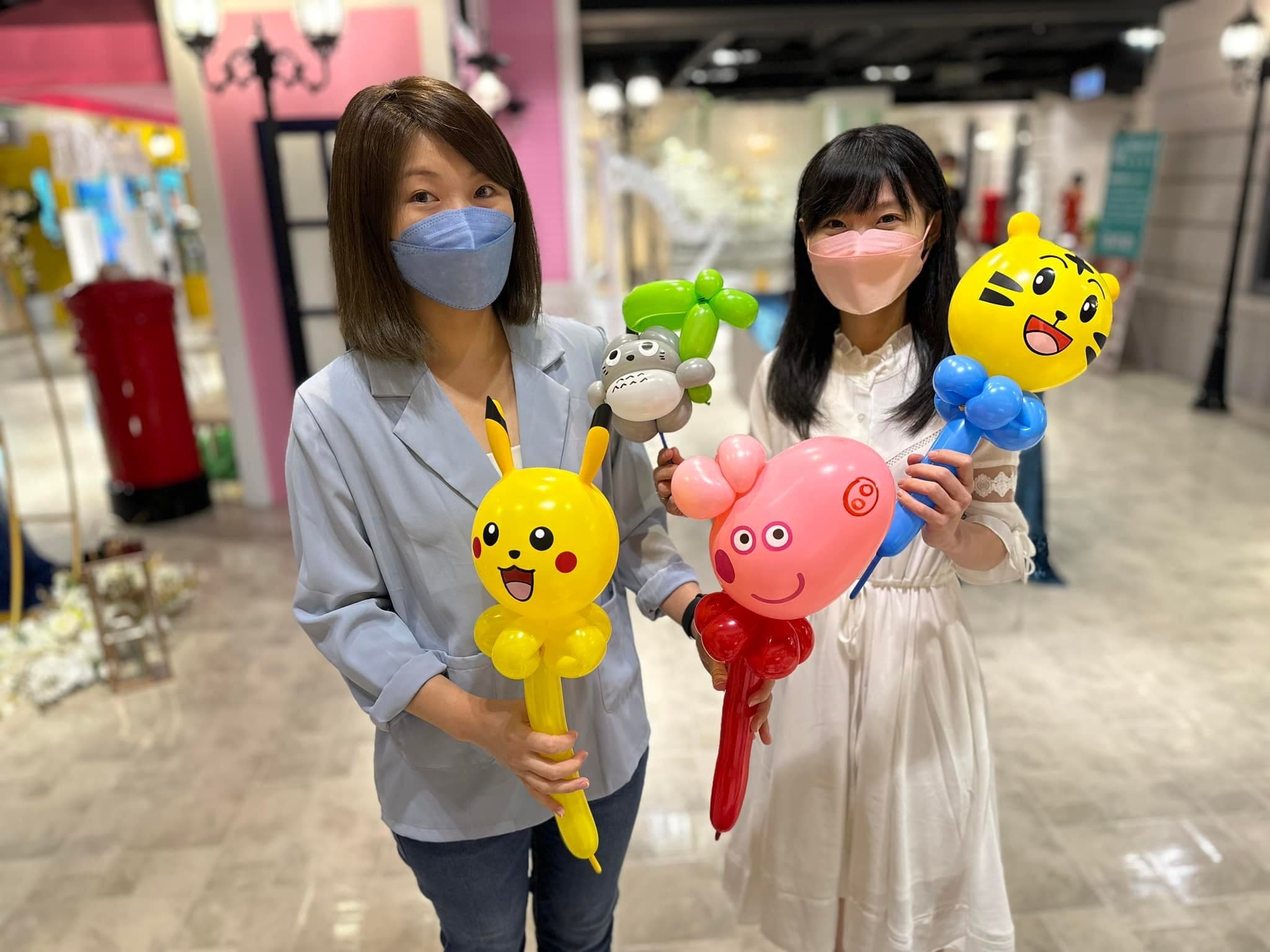 兩位女賓客拿著皮卡丘、龍貓、佩佩豬與巧虎造型氣球棒