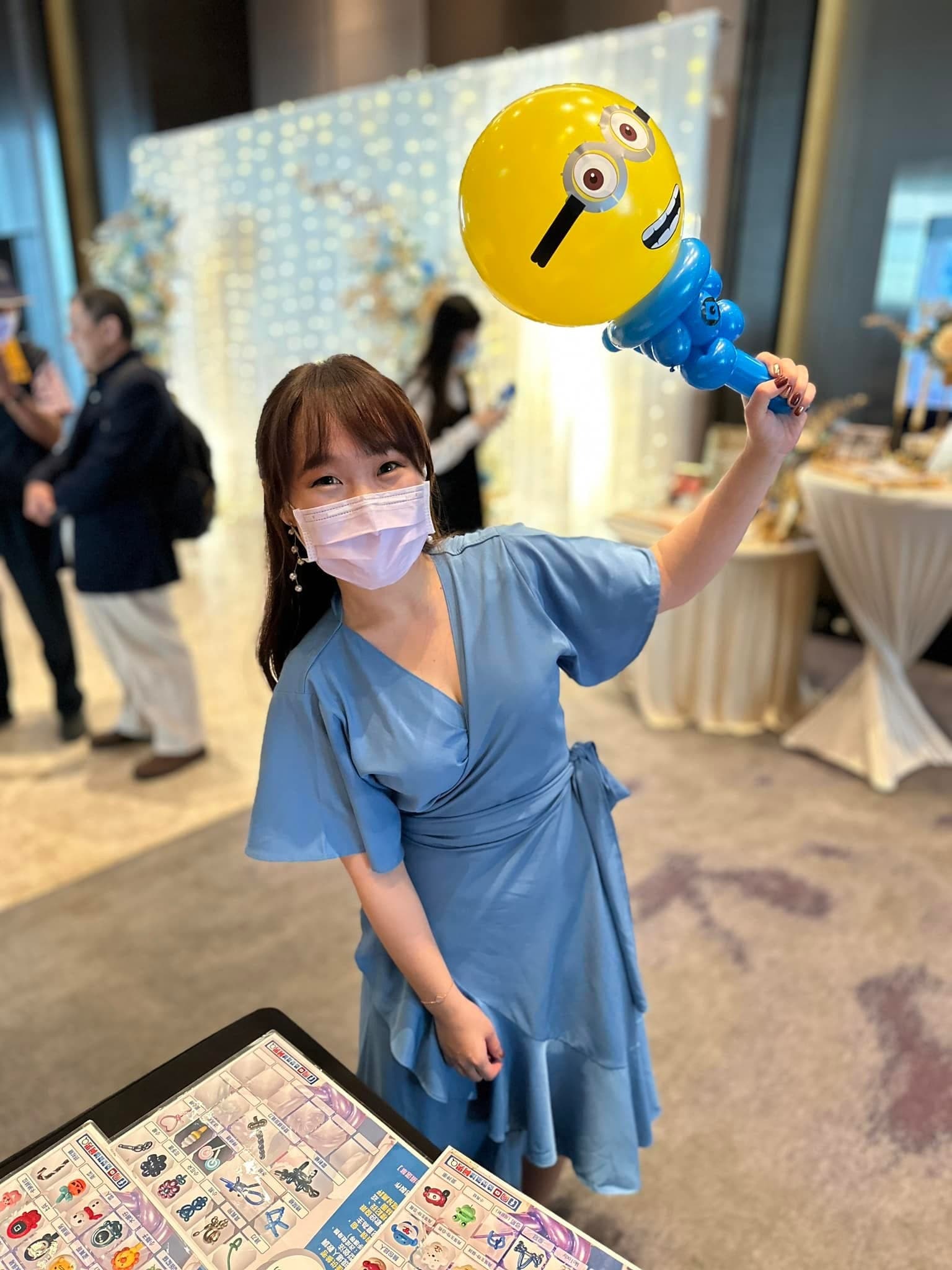 穿藍色洋裝的女賓客高舉小小兵造型氣球