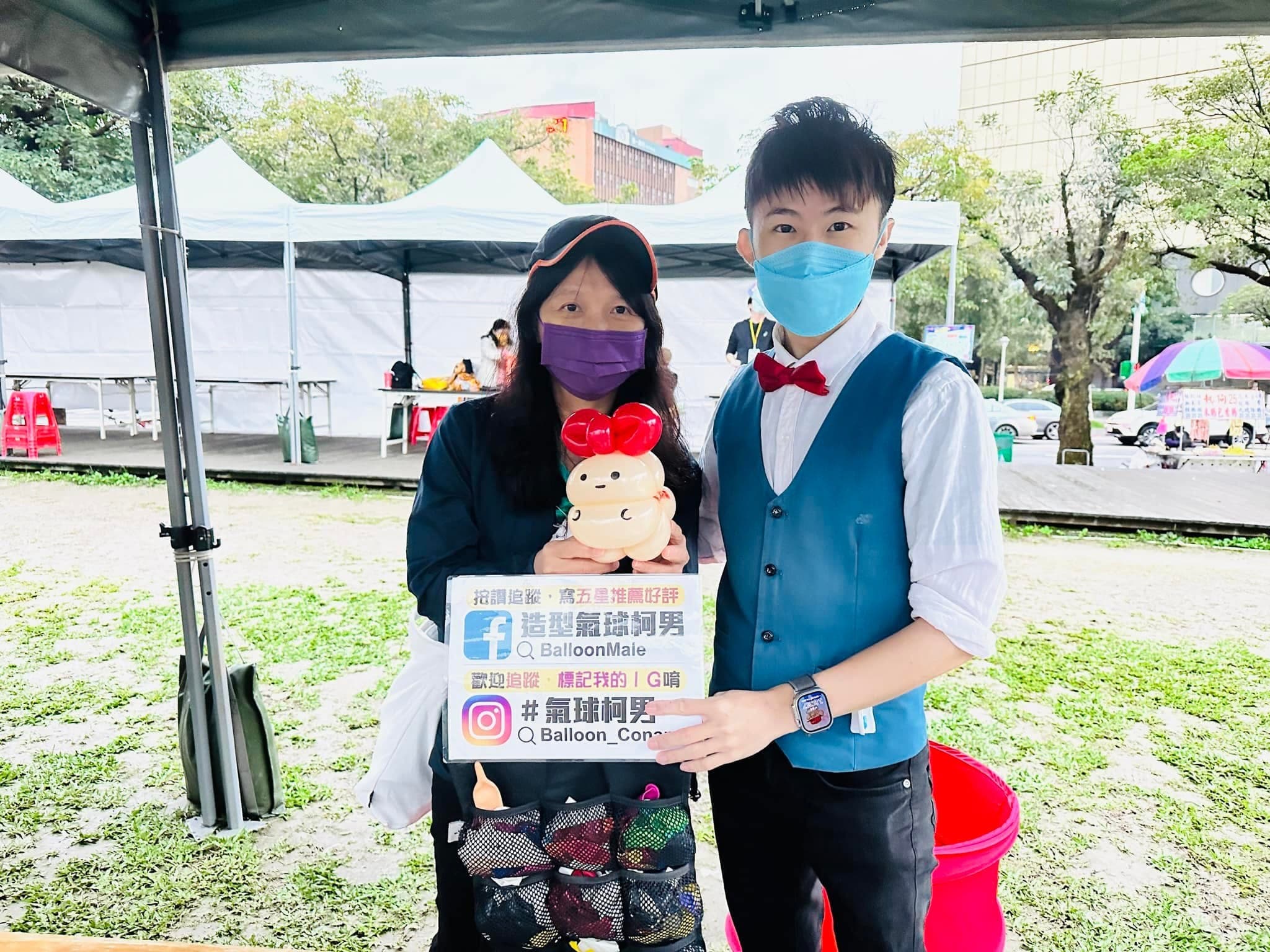 柯男和民眾在華山帳篷攤位前合照，民眾抱著戴紅色蝴蝶結的米白色小熊氣球