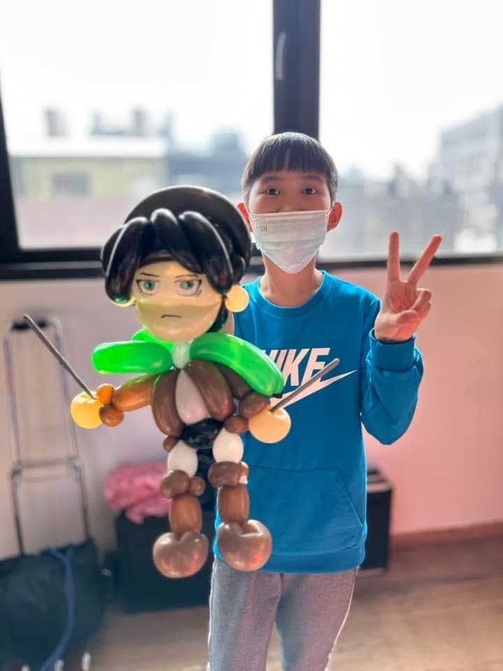 穿藍色上衣的男孩比 YA，旁邊是綠色披風的兵長造型氣球