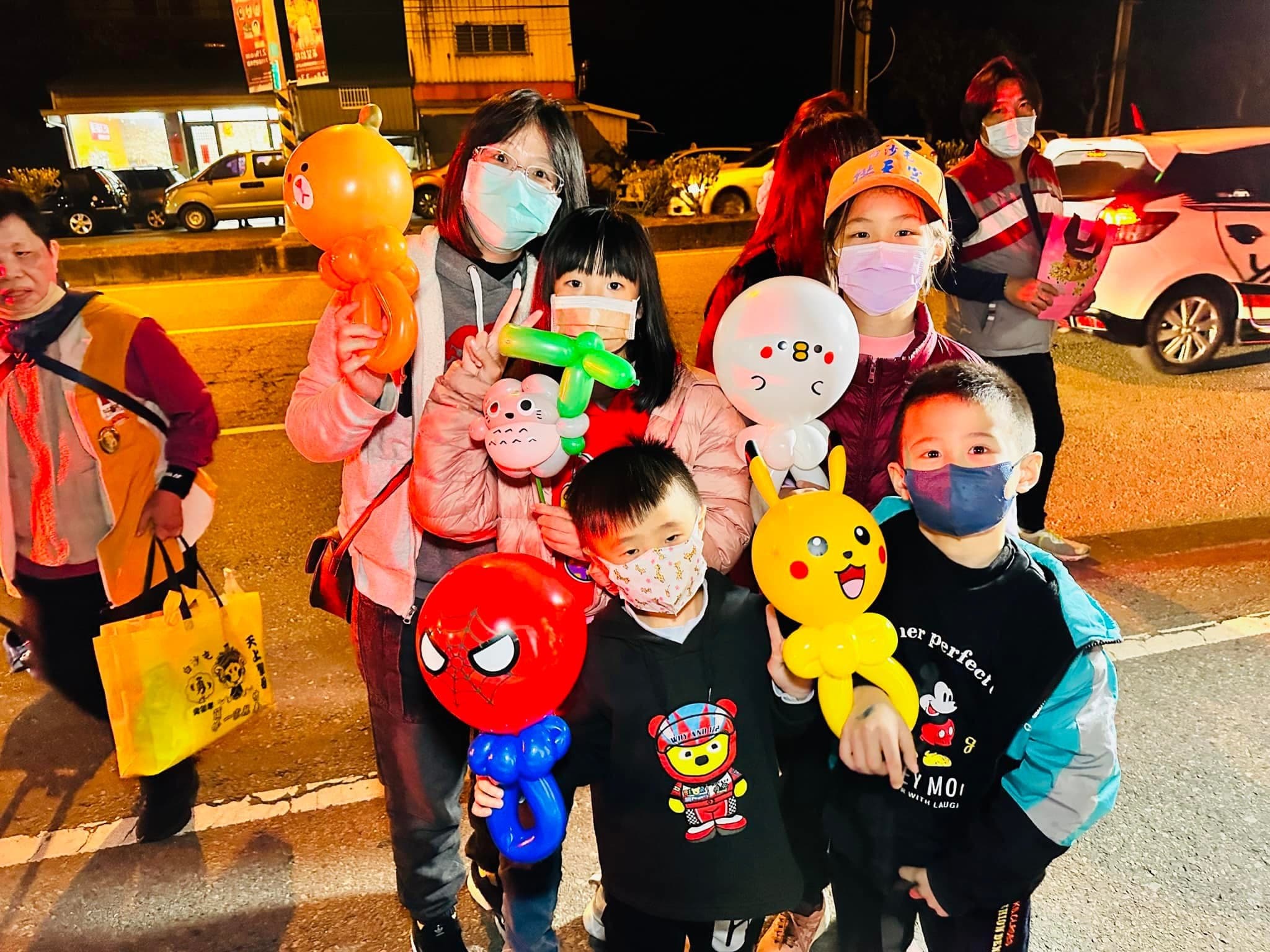 進香路上的孩子們拿著蜘蛛人、皮卡丘、白色小狗等造型氣球