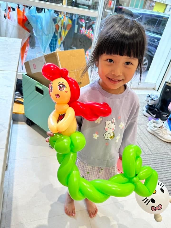 笑咪咪的女孩拿著綠色長魚尾的小美人魚氣球