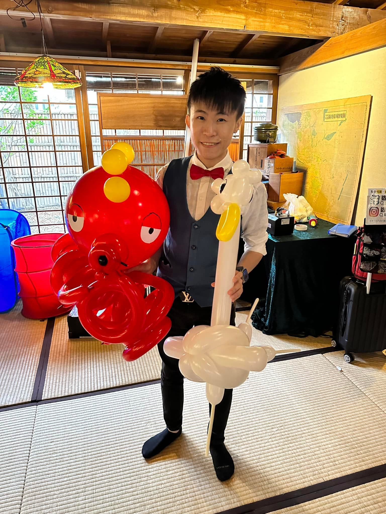 柯男抱著大型紅色章魚造型氣球與白色長頸鳥造型氣球