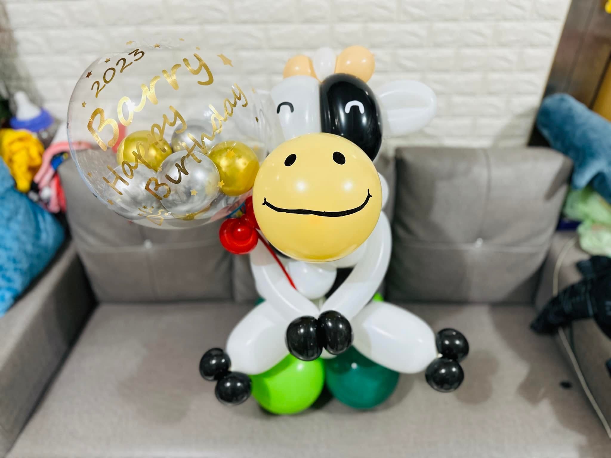 黑白乳牛造型氣球抱著寫有生日祝福的透明波波球