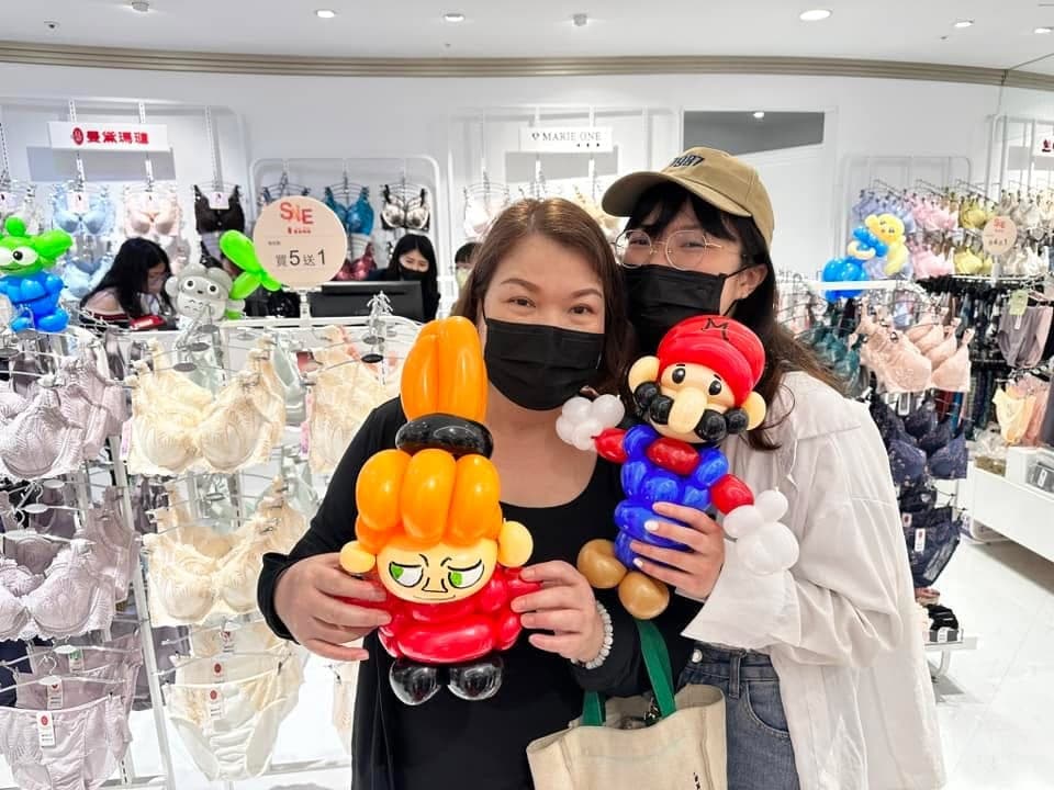 兩位顧客在專櫃前拿著瑪利歐與橘色髮髻角色氣球