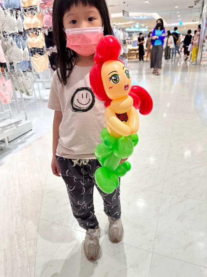 小女孩拿著紅髮綠尾的小美人魚造型氣球