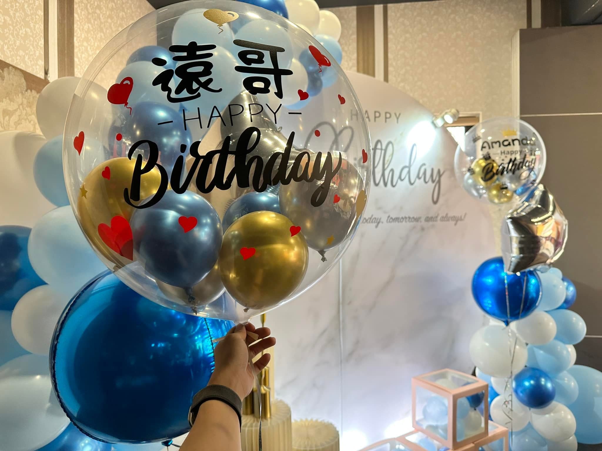 手拿裝著金色、藍色小氣球的客製中文名字生日波波球