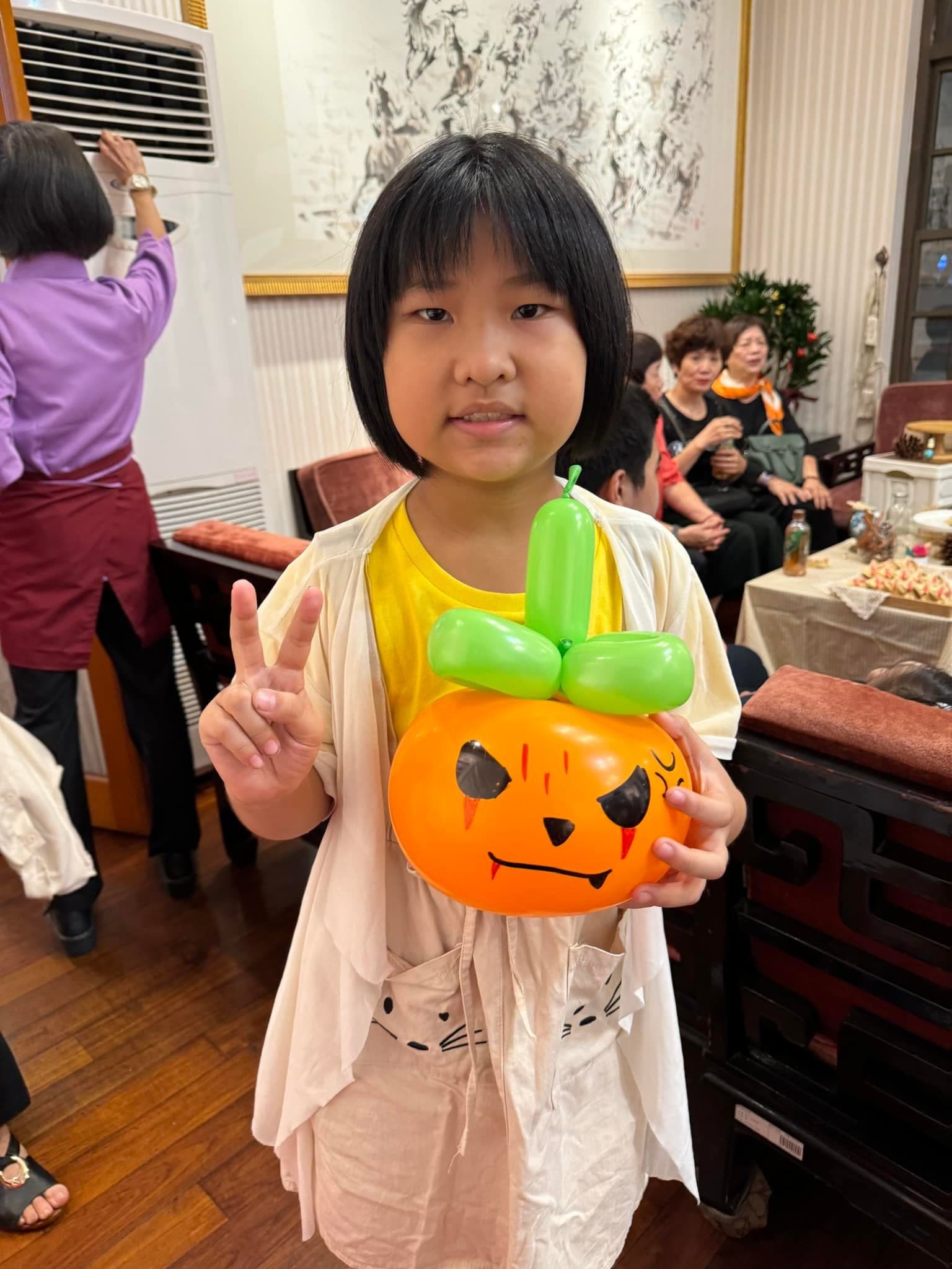 婚宴上的女孩比 YA，抱著橘色南瓜造型氣球