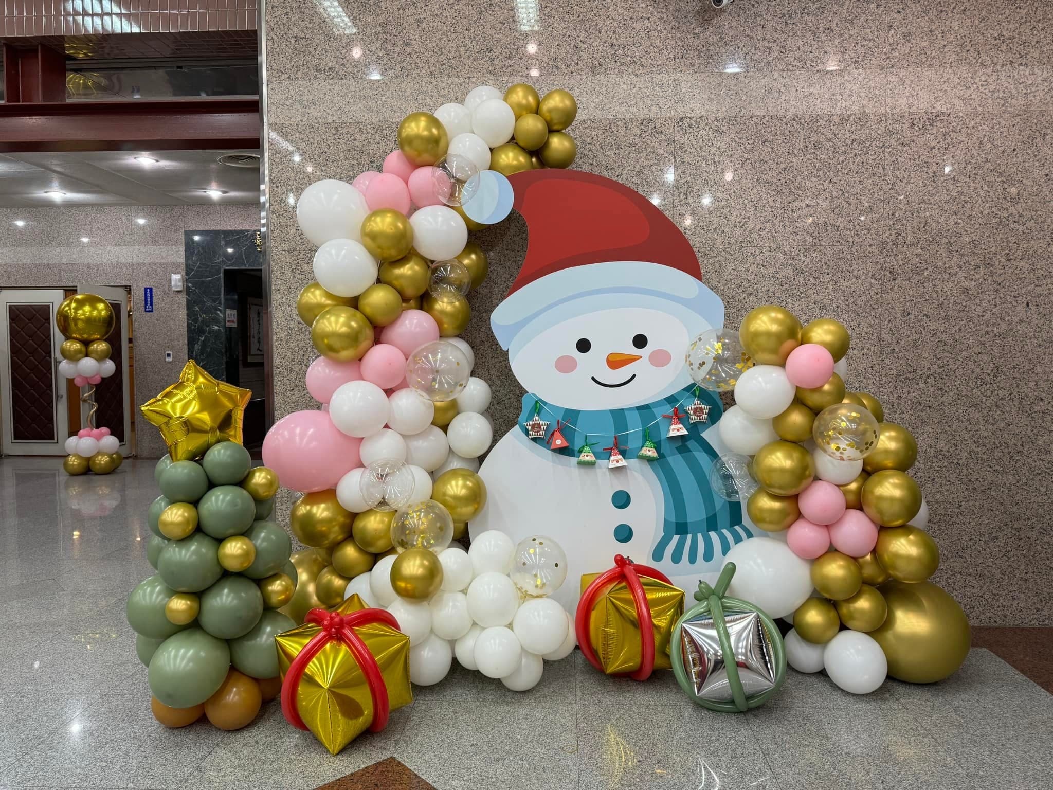新北板橋聖誕佈置，雪人造型背板旁是金粉白氣球串與聖誕樹氣球