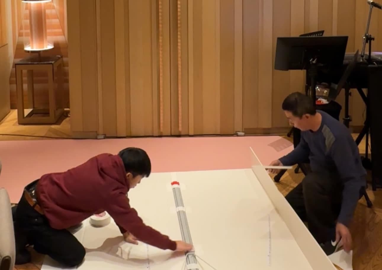 柯男和爸爸跪在地上組裝白色背板與粉色布面