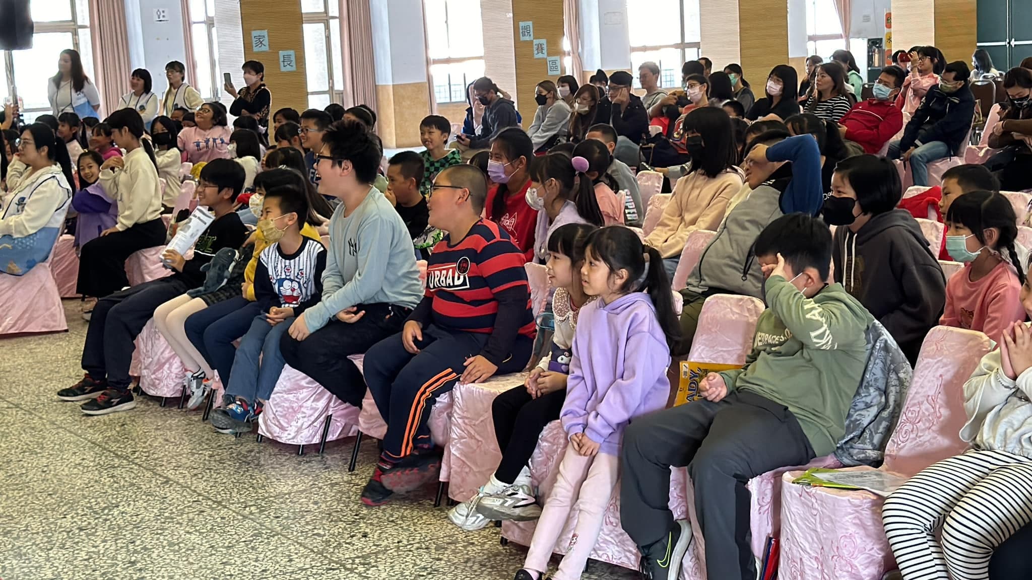 參賽的孩子和家長坐滿禮堂座位，專心看向舞台