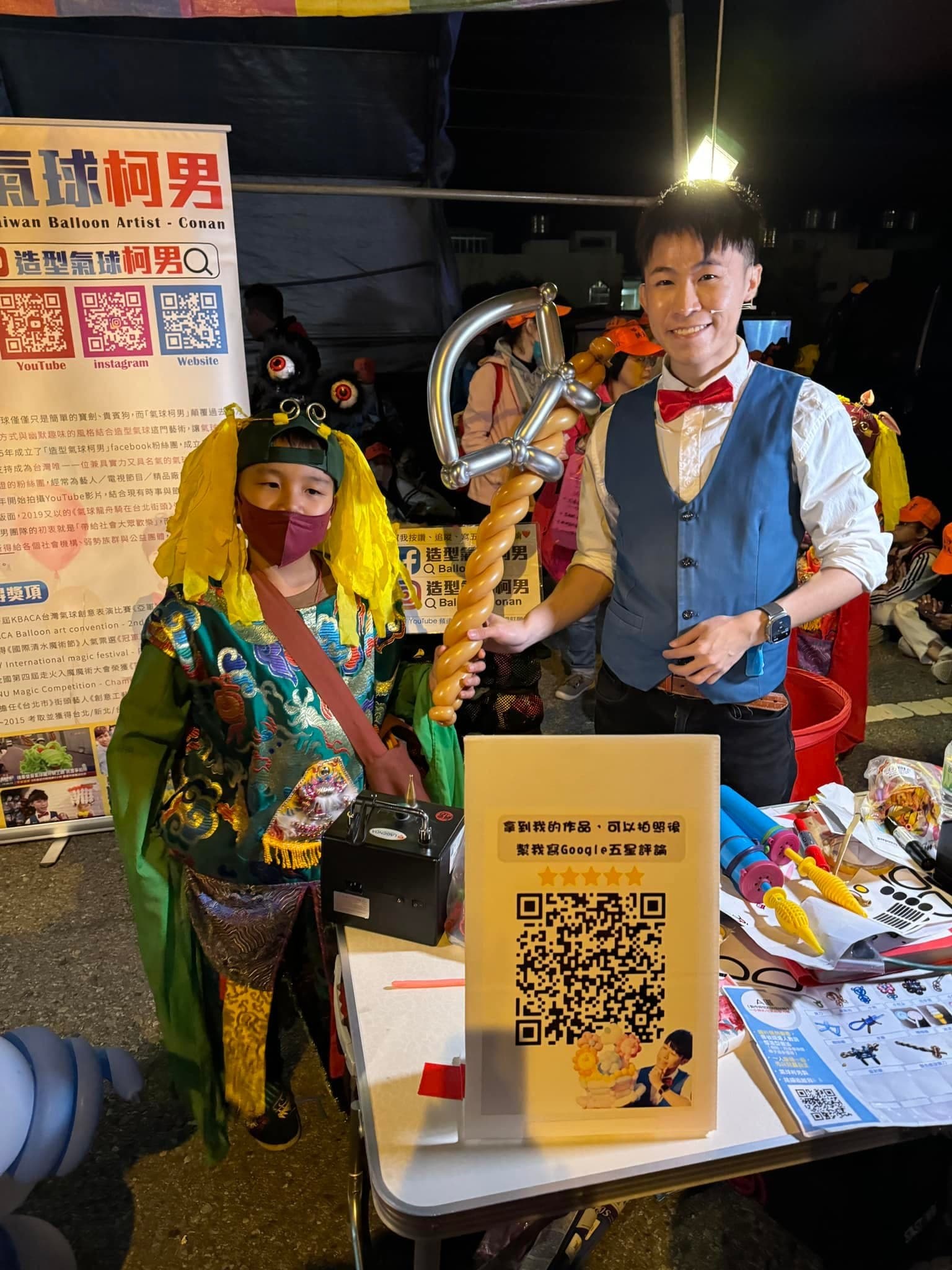 柯男遞出金銀色權杖造型氣球給神明裝扮的孩子