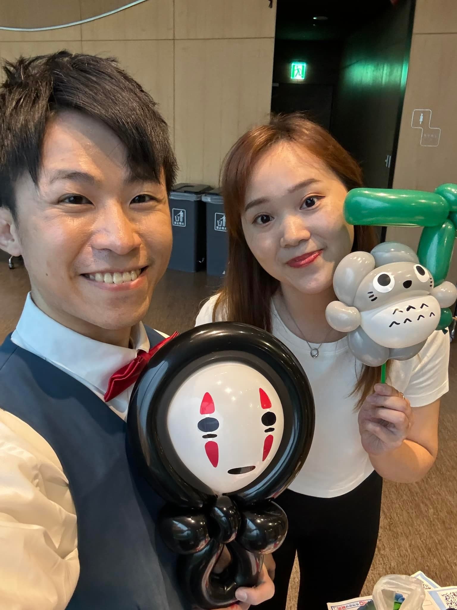 柯男自拍，身旁女士拿著無臉男與龍貓造型氣球