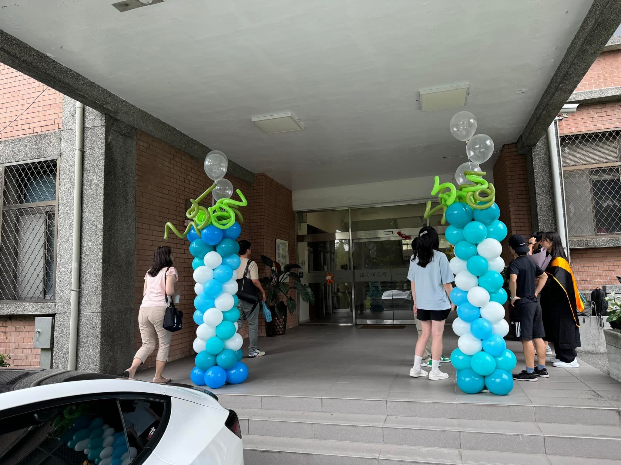 系館入口兩側的藍白螺旋氣球柱，頂端有透明泡泡氣球