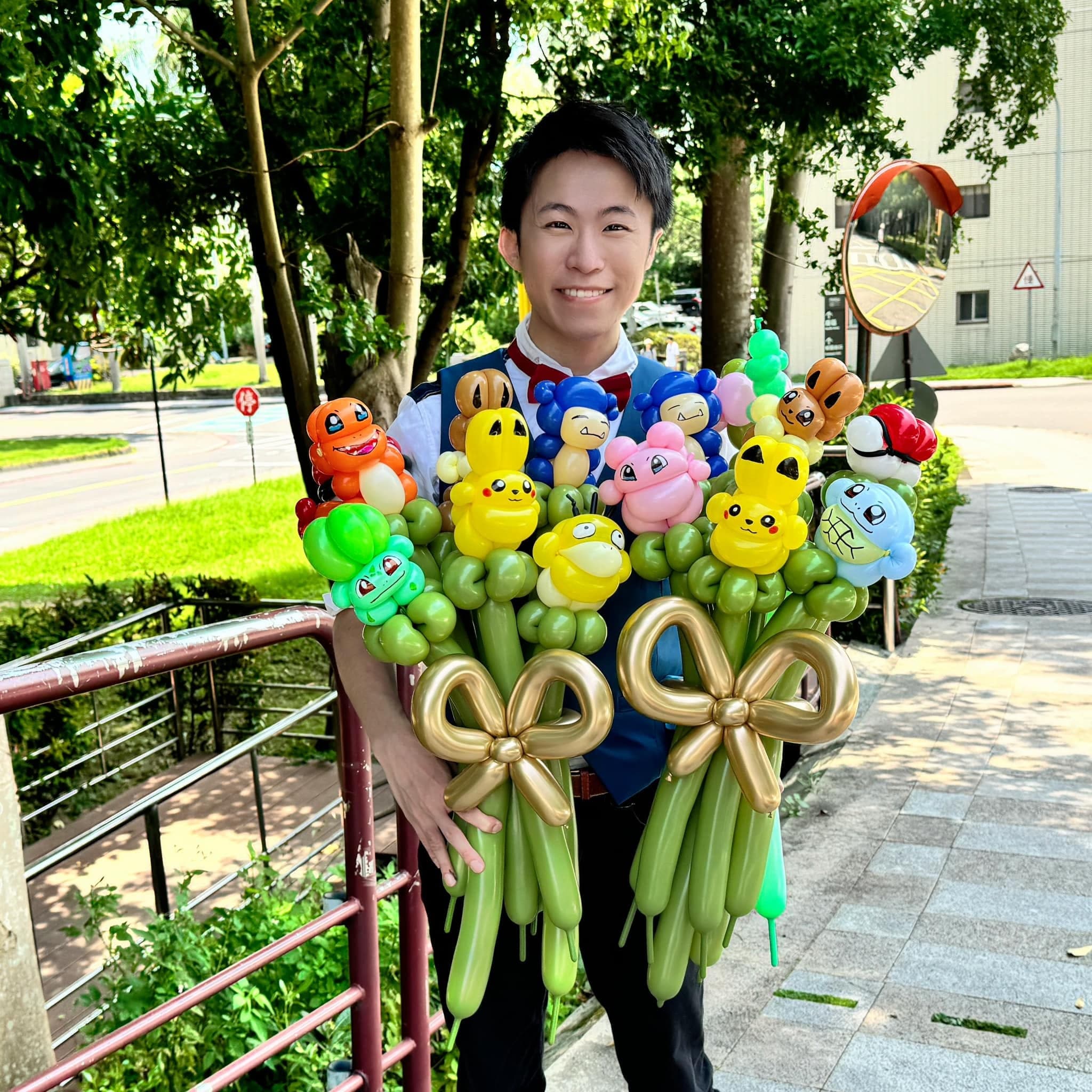 柯男在戶外雙手抱著兩束寶可夢氣球花束，綁著金色蝴蝶結
