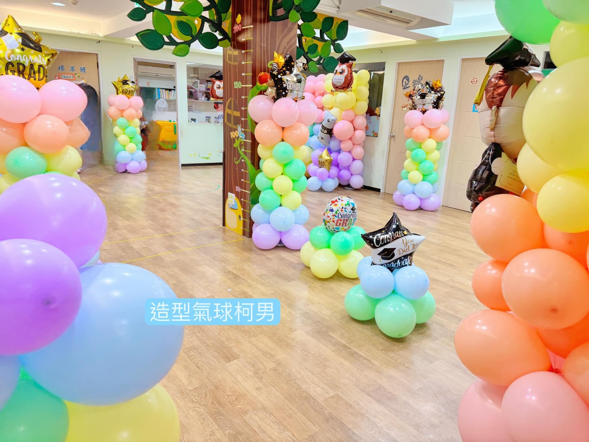 幼兒園教室內大樹造型柱旁立著多根馬卡龍色畢業氣球柱