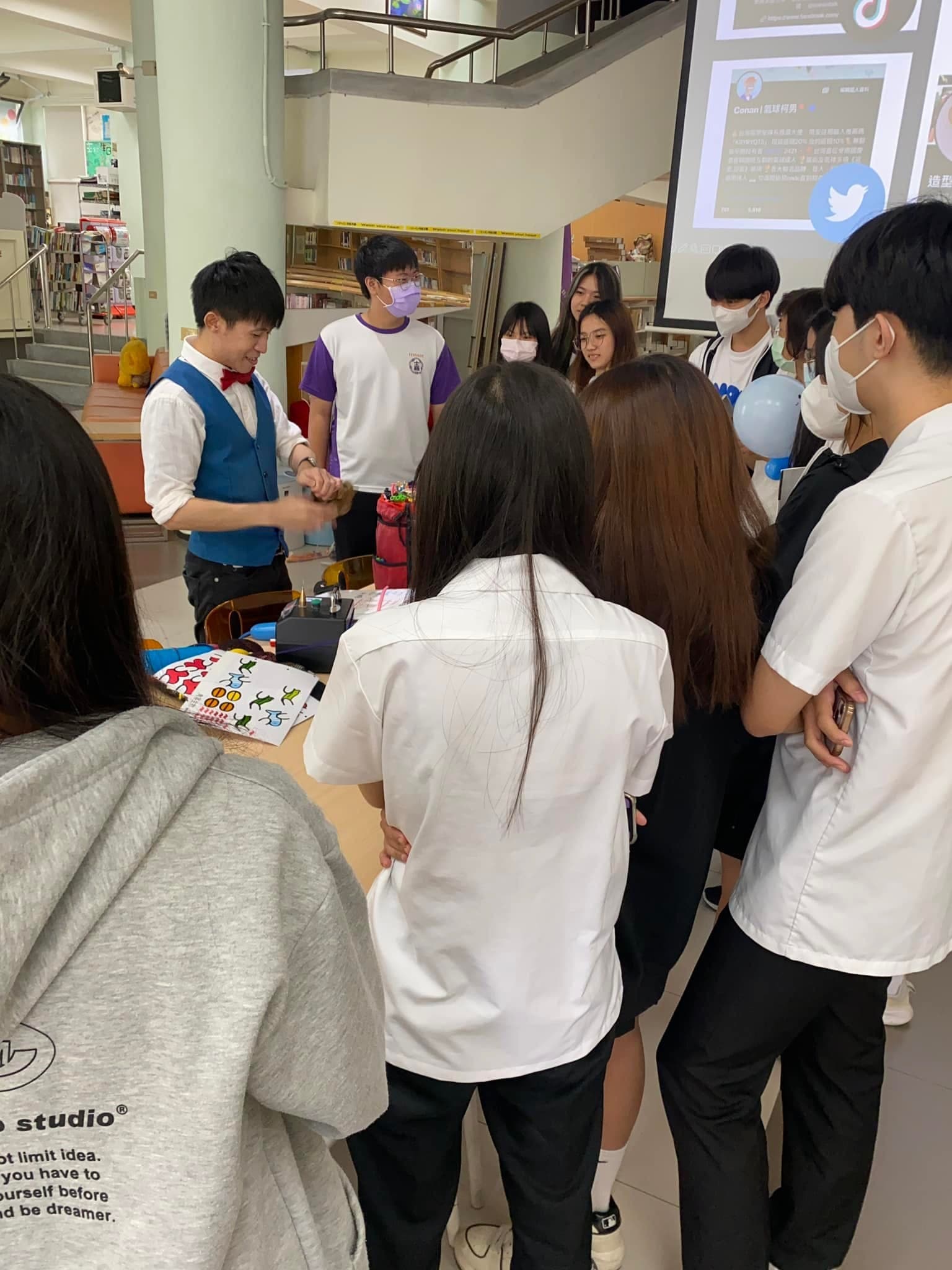 下課時一群學弟妹圍著柯男看他現場折氣球