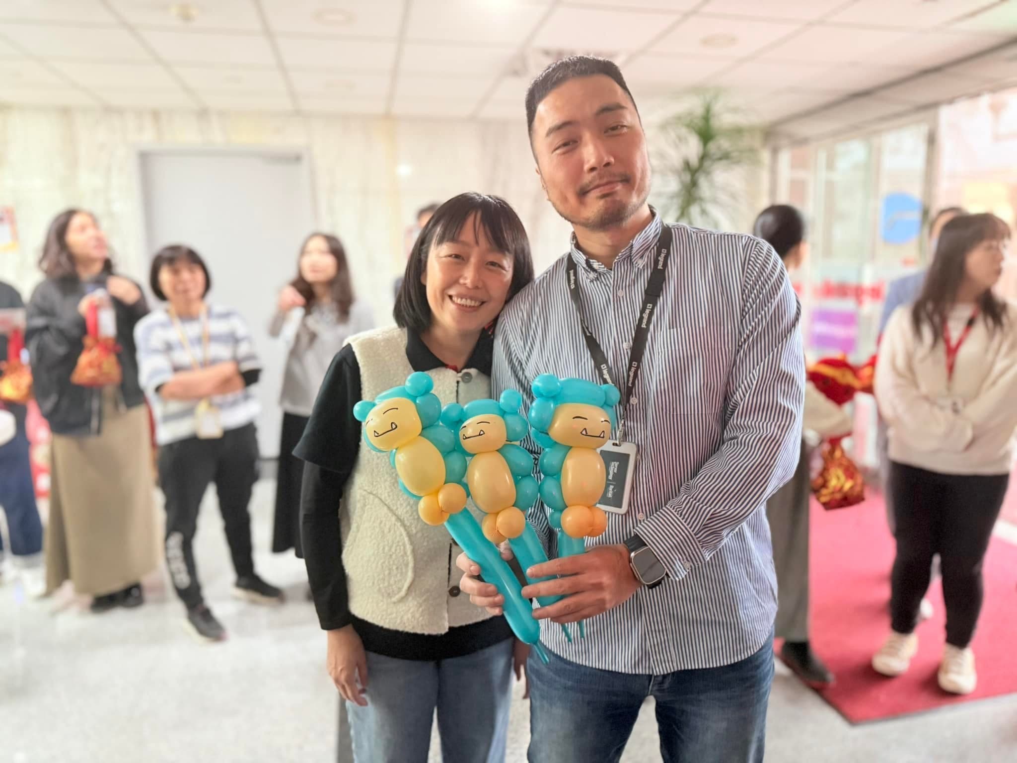 一男一女拿著三支卡比獸造型氣球棒合照