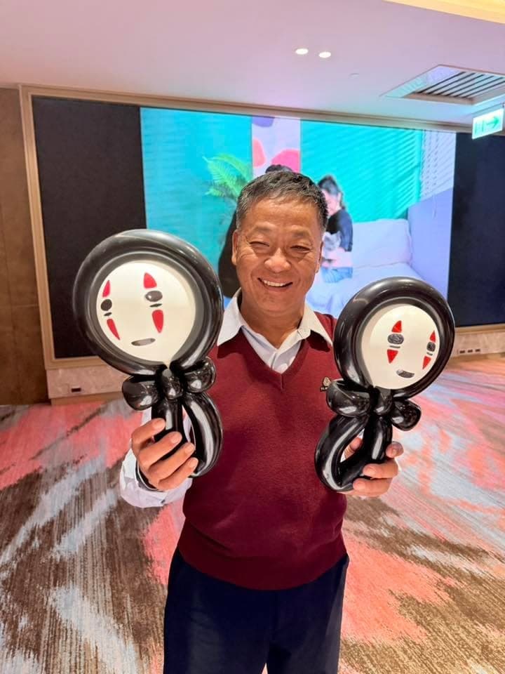 1 月另一場婚禮：長輩笑著雙手各拿一個黑色無臉男氣球