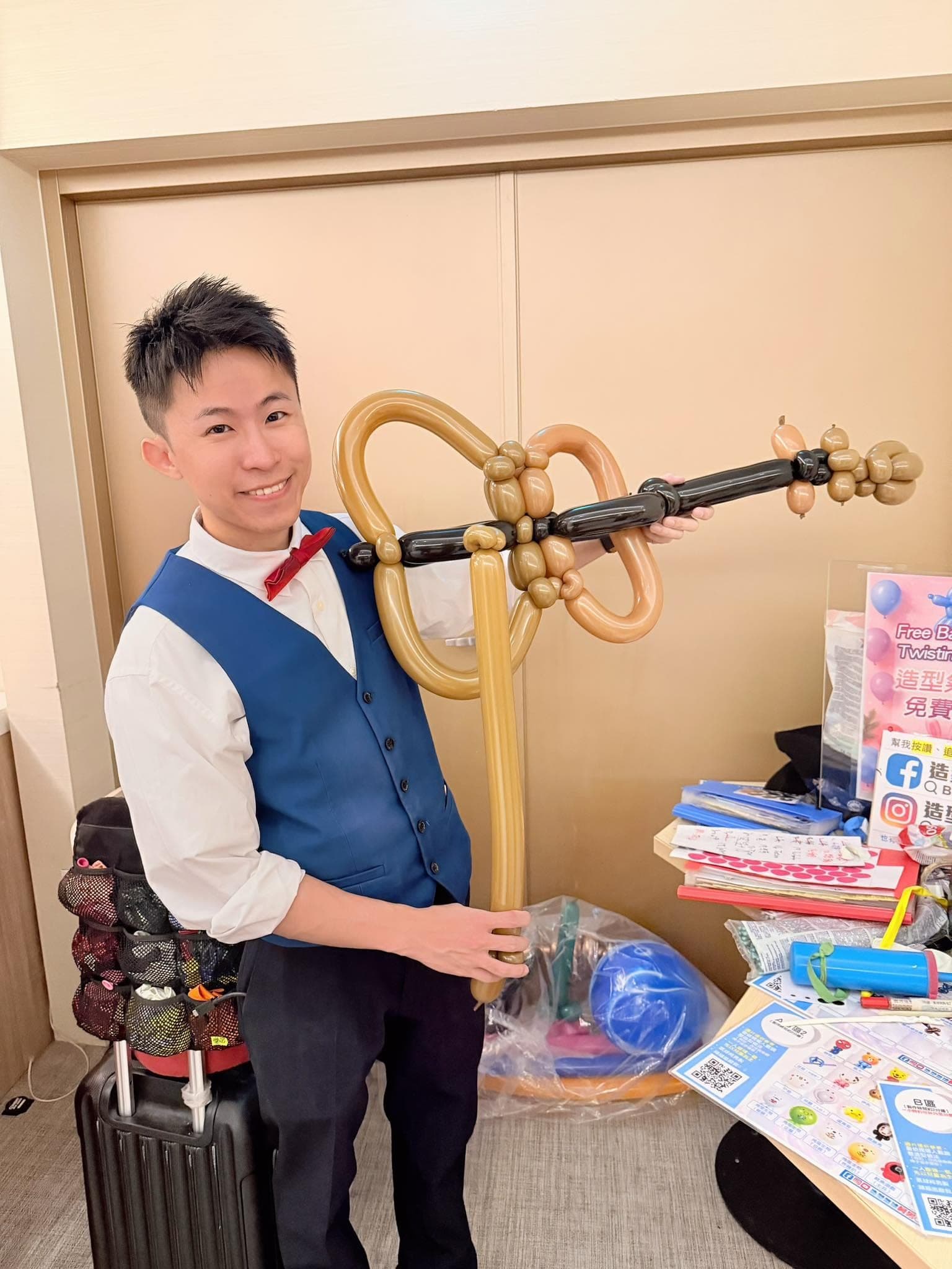 12 月另一場：柯男雙手拿著金色琴身黑色琴頸的小提琴氣球