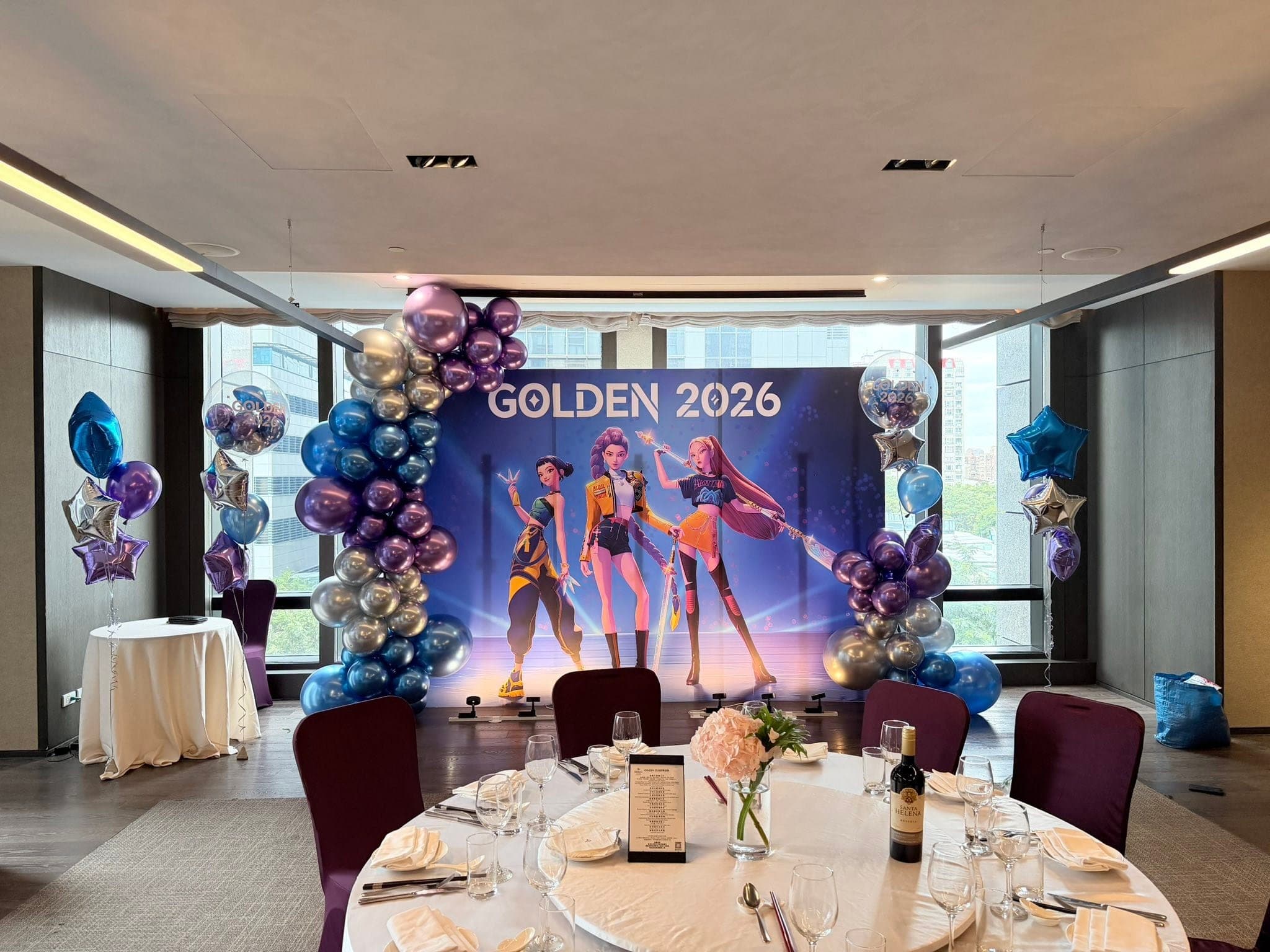 12 月另一場：用餐圓桌與花藝前的 GOLDEN 2026 背板