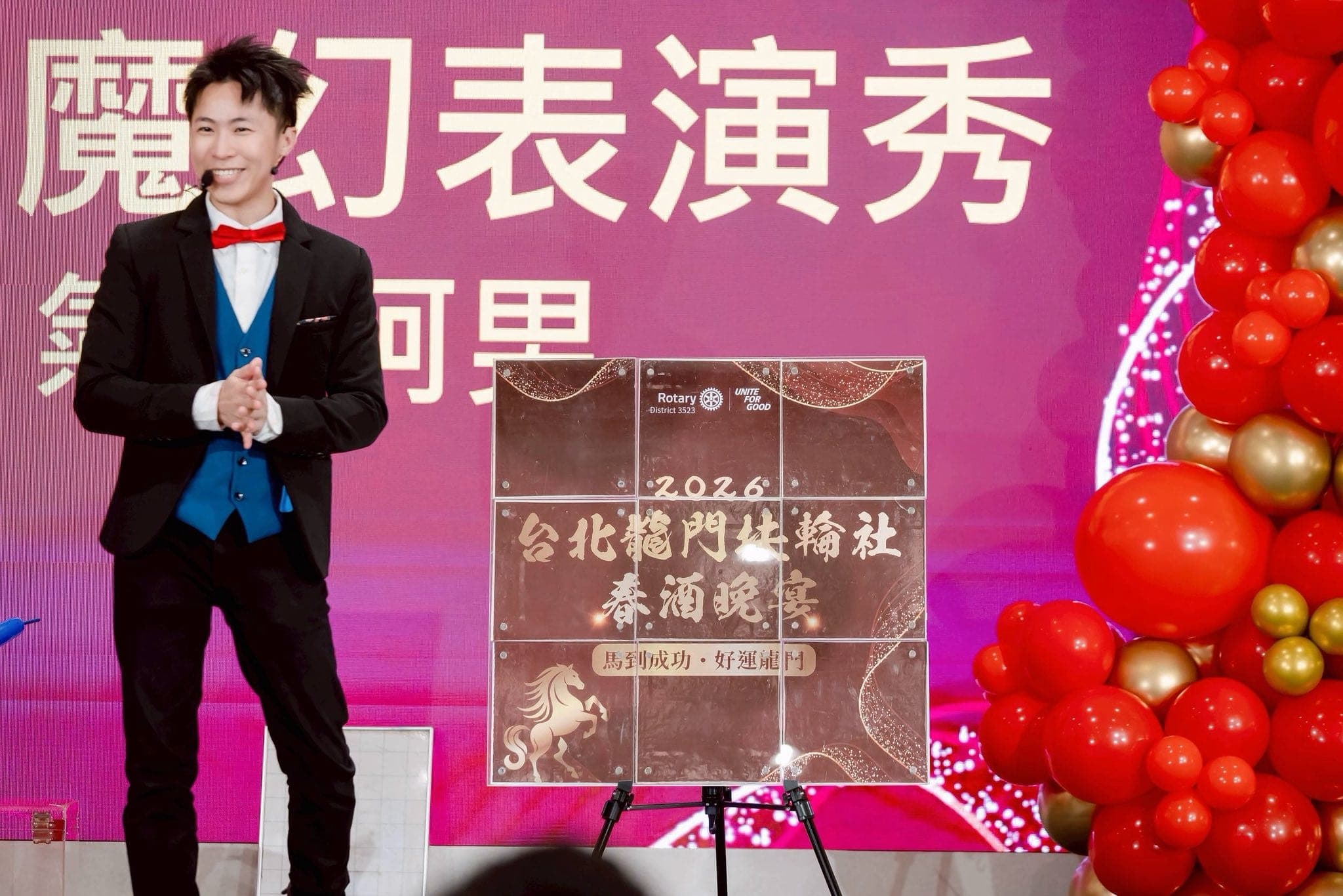 台北龍門扶輪社春酒晚宴舞台上，柯男站在春酒晚宴看板旁