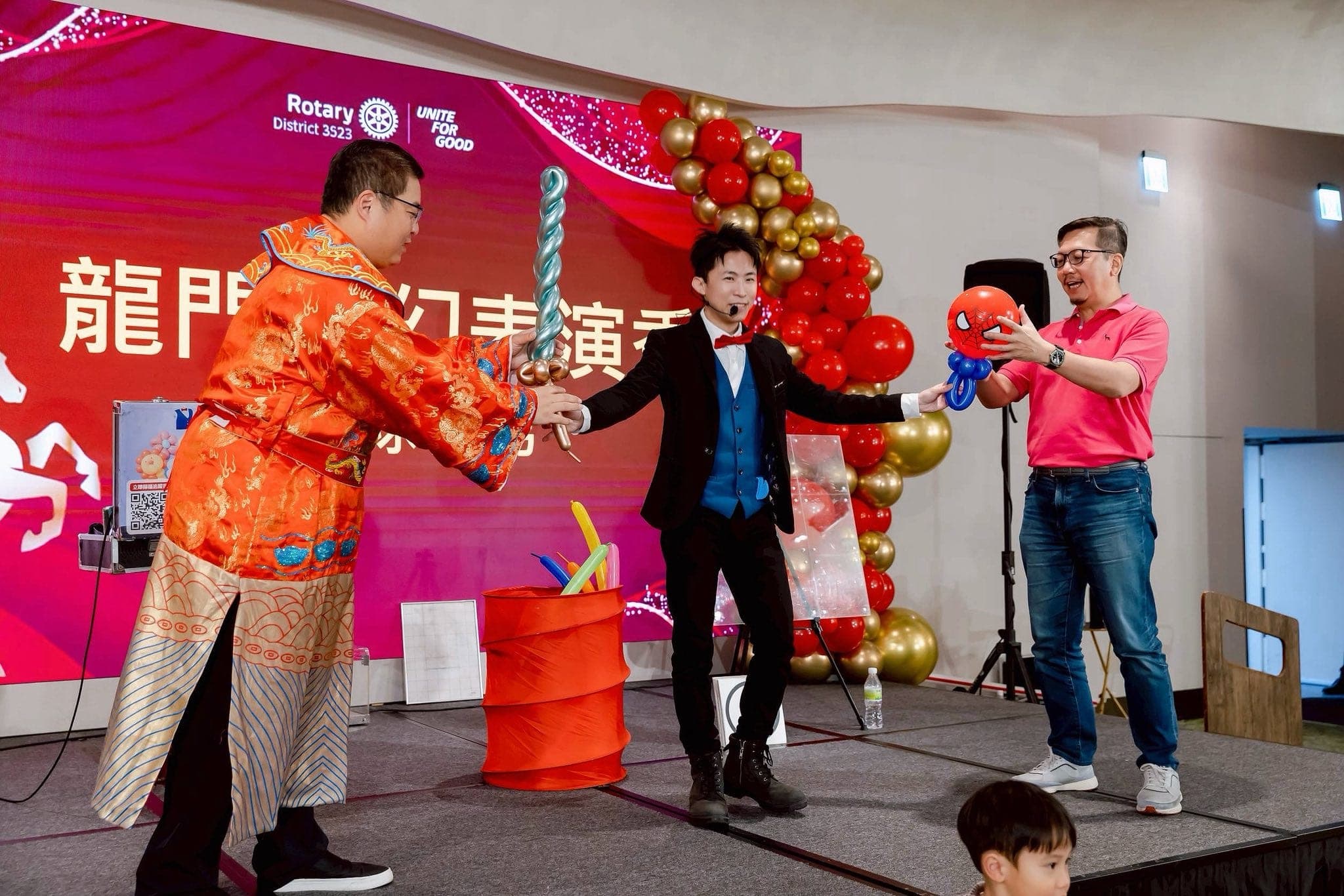 穿古裝與粉紅上衣的來賓在春酒舞台上配合柯男表演魔術