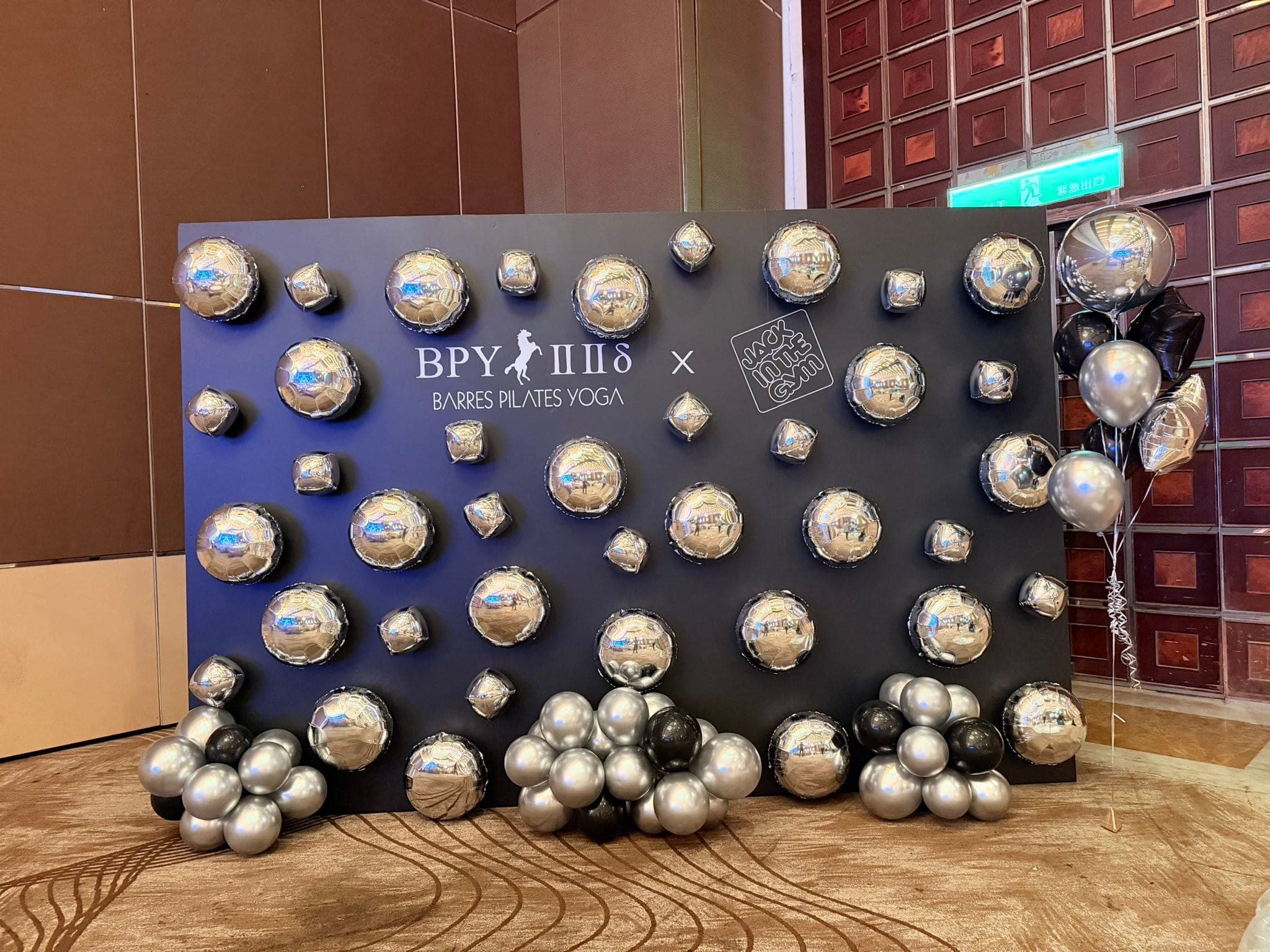 黑色 BPY 背板上黏滿大小不一的銀色鋁箔氣球，下方堆著銀黑色氣球串，右側有黑銀空飄氣球