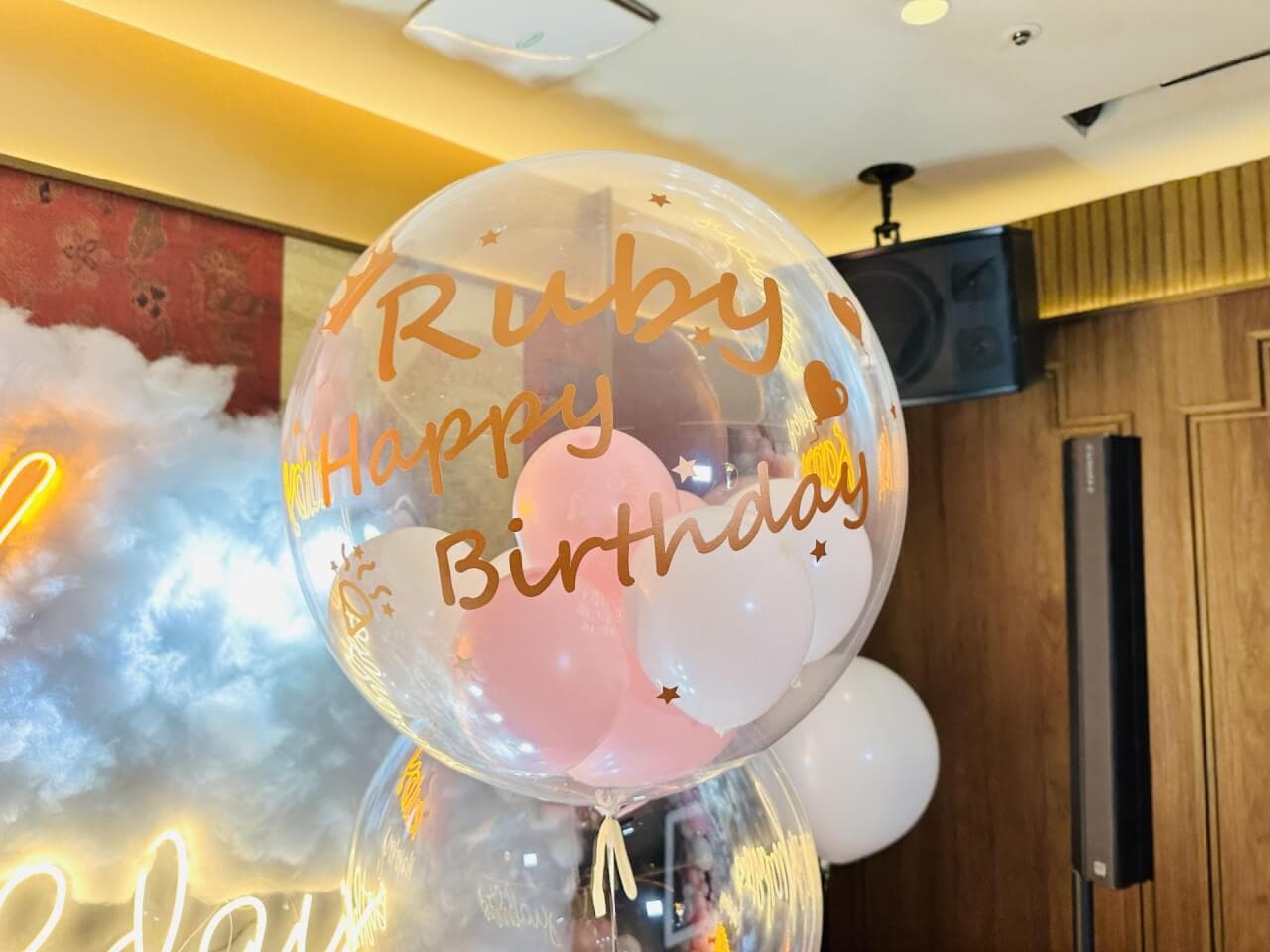 透明波波球印著金色 Ruby Happy Birthday 字樣，裡面裝著粉紅與白色小氣球