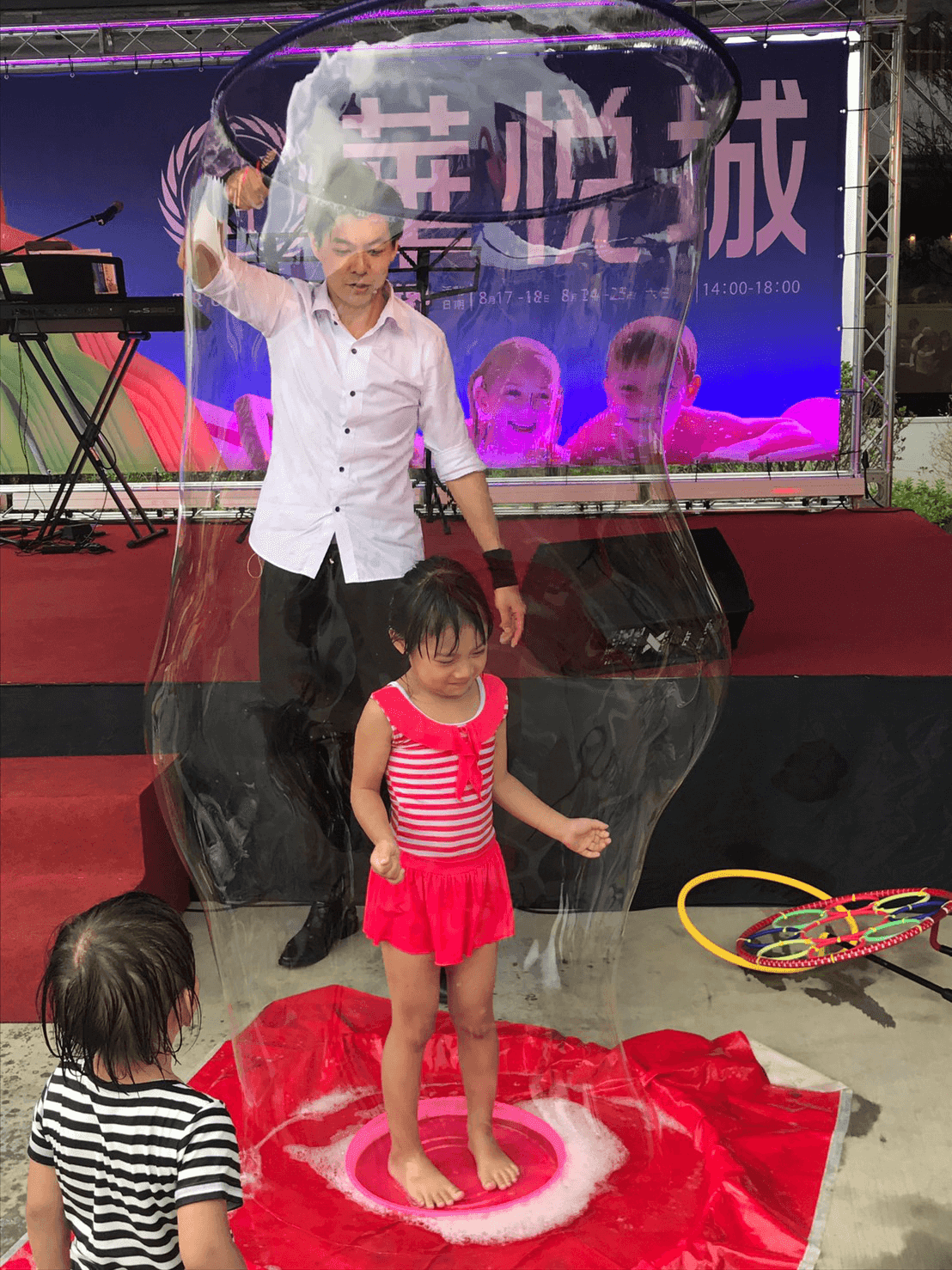 舞台上的大泡泡把小女孩包圍起來