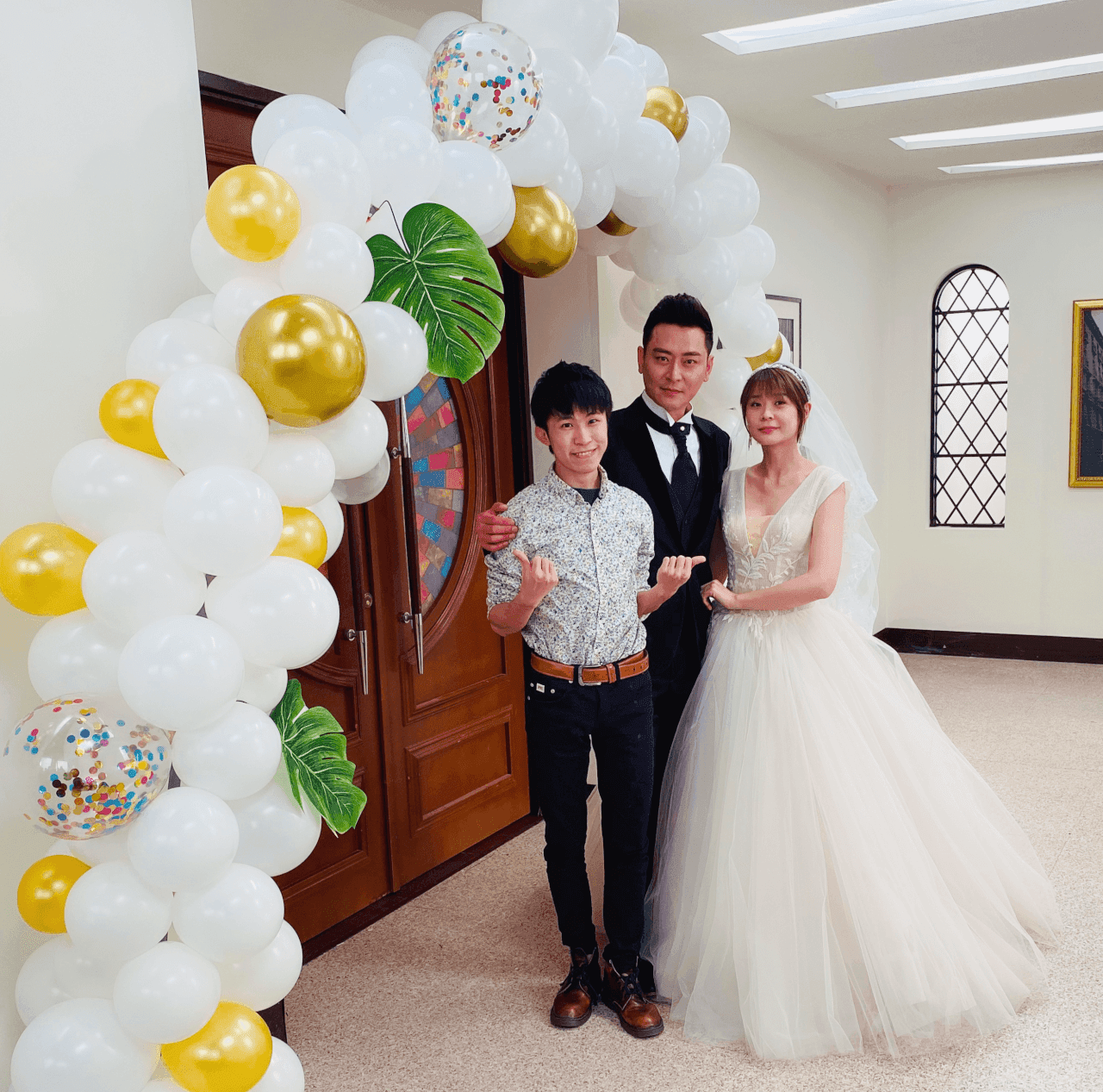 炮仔聲教堂場景白金氣球拱門前，我與穿婚紗、禮服的演員合照