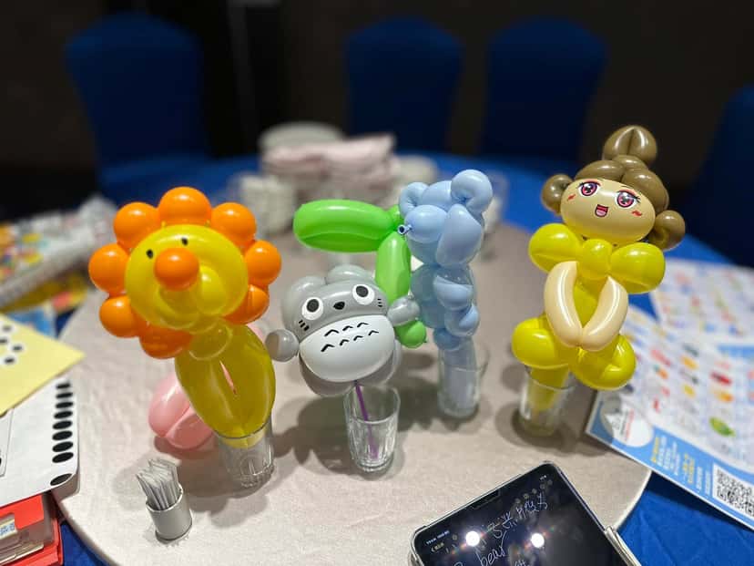 桌上插著獅子、龍貓、藍色小熊與黃色公主造型氣球