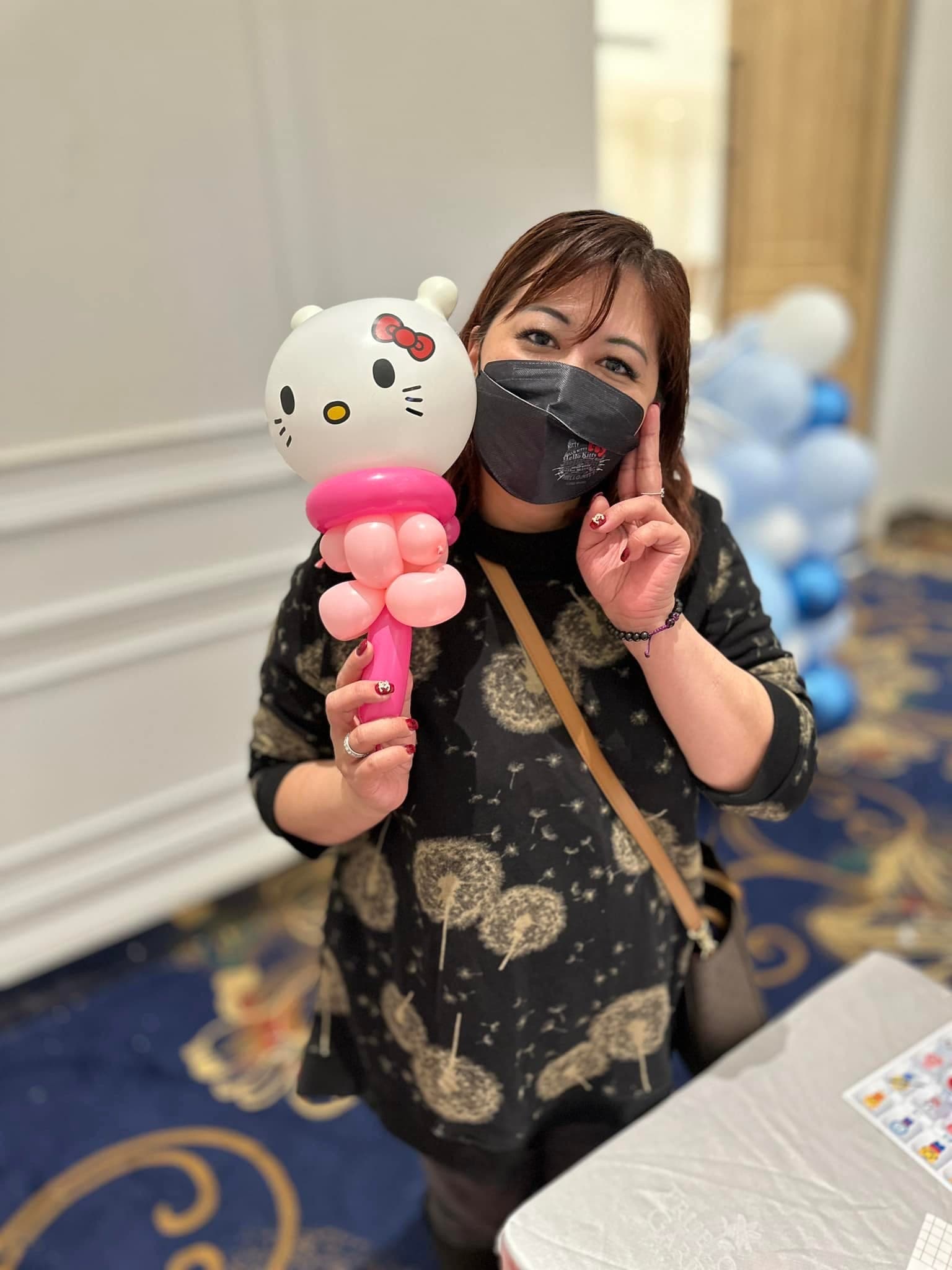 女賓客拿著 Hello Kitty 頭與粉紅握把的造型氣球棒