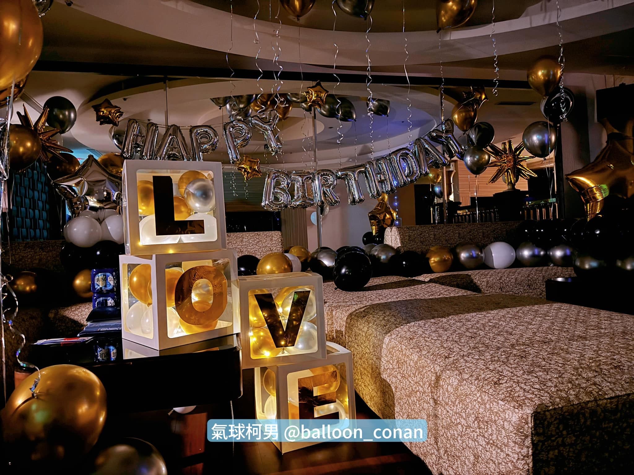 關燈後 LOVE 字母燈箱透出暖黃光,後方掛著銀色 HAPPY BIRTHDAY 字母氣球