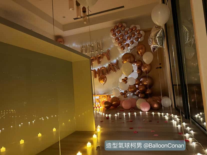 客廳地板一路排著電子蠟燭,引導走向氣球佈置牆