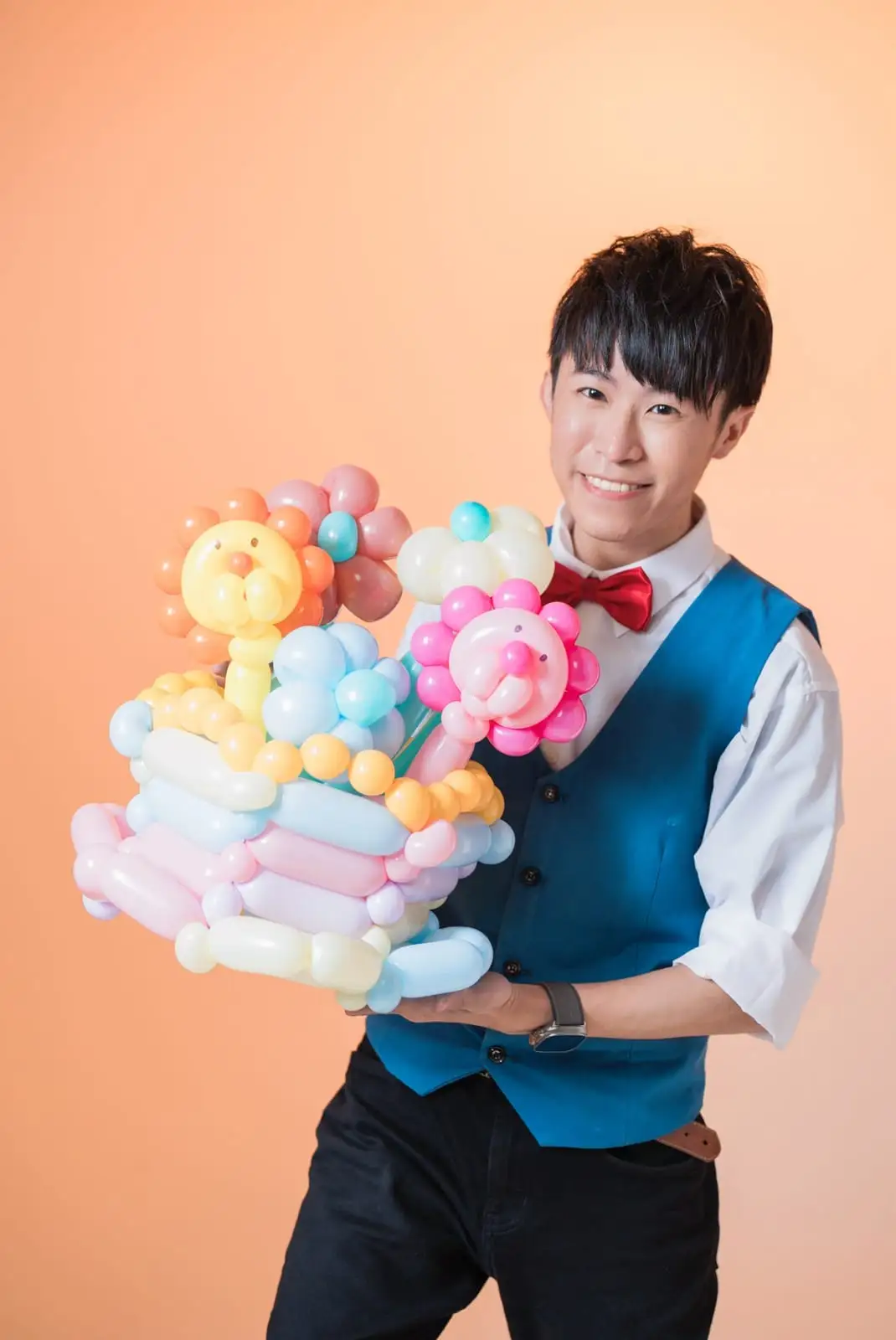 氣球達人柯男捧著獅子花朵造型氣球微笑的形象照