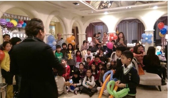 永和社區生日派對魔術表演，小朋友坐在地上，手拿造型氣球