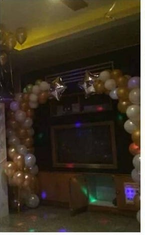 尾牙會場的金色、白色、香檳色氣球拱門，頂端點綴銀色星星