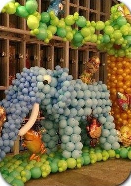 淺藍色氣球大象雕塑,站在綠色氣球草地上