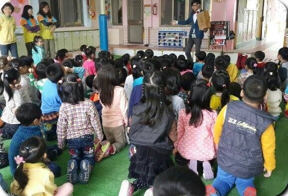 華聲幼兒園小朋友坐滿草皮，老師在旁陪同看表演