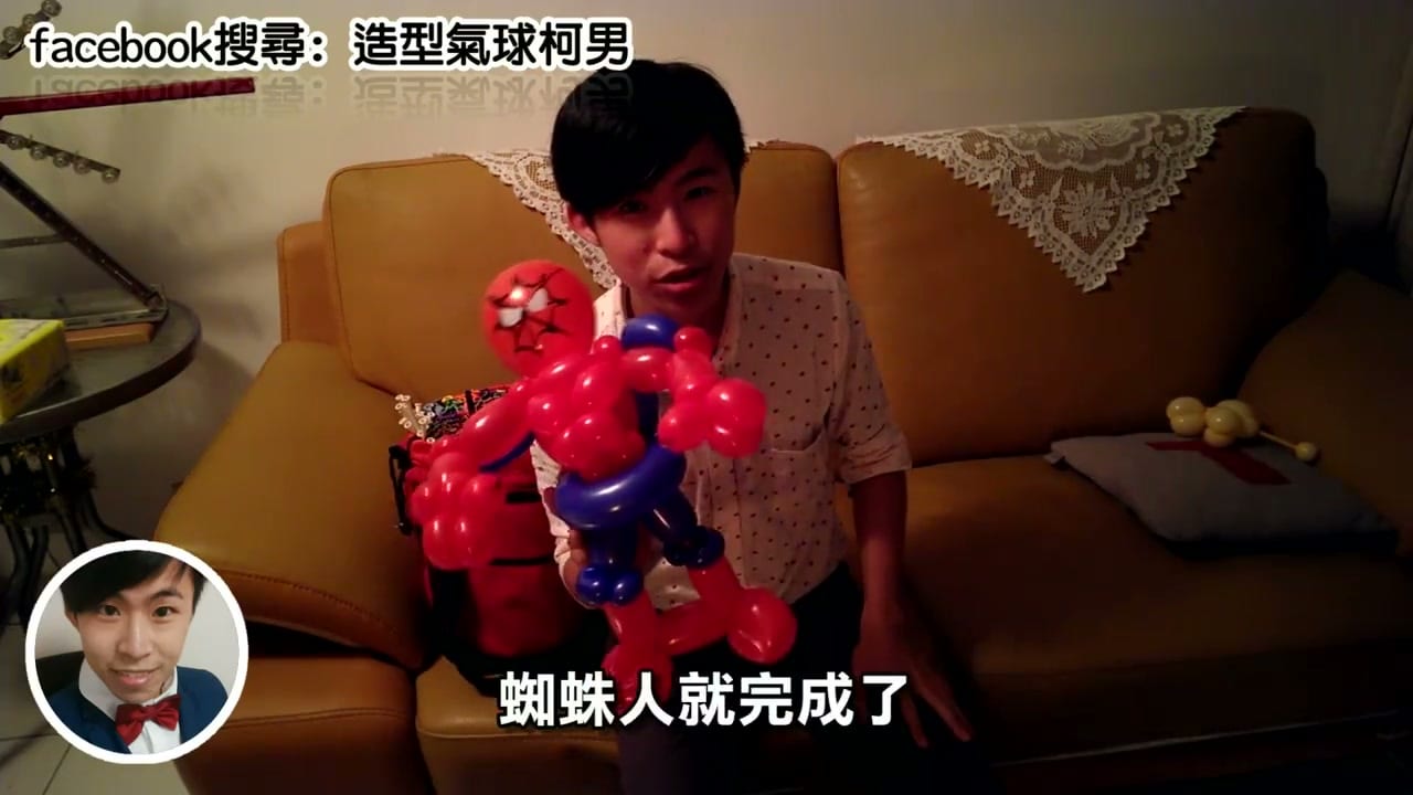 柯男雙手舉起剛完成的紅藍色蜘蛛人造型氣球