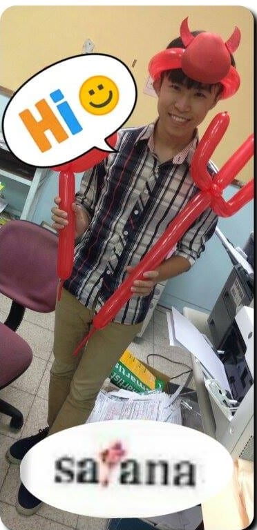 戴紅色惡魔角帽子、拿兩支惡魔叉子氣球的男生