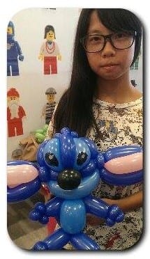 戴眼鏡的女孩拿著藍色史迪奇造型氣球