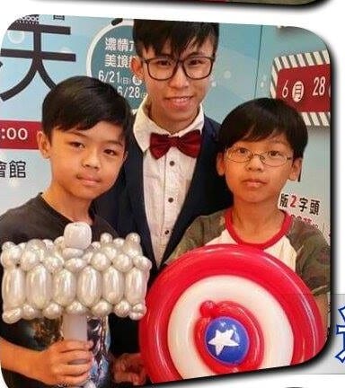 兩個男孩拿著銀色大寶劍和美國隊長盾牌與柯男合照
