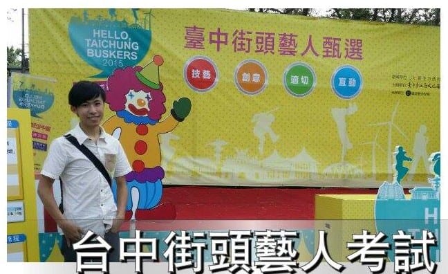 臺中街頭藝人甄選看板前，柯男背著包包站在舞台邊