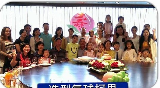 壽宴包廂裡一大家人在圓桌後方合照