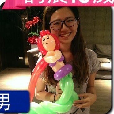 戴眼鏡的女生拿著小美人魚造型氣球