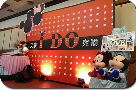 紅色珍珠背板「I DO」，旁邊擺著米奇米妮玩偶