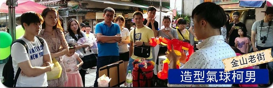 新北金山老街現場折氣球，遊客圍在攤位前看柯男折造型